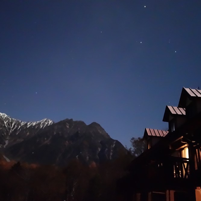 二階のテラスから夜の星空と山